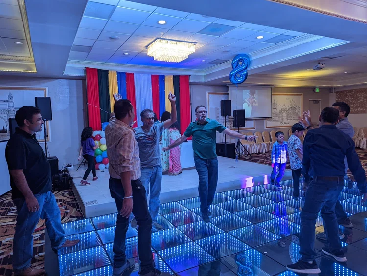 The Shubham Story 5 Guests celebrating together on the illuminated dance floor at Shubham Halls